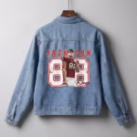 Product photography of a custom denim jacket with a personalized football player graphic, name, and number on a grey background.
